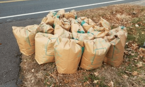 sacchetti di calcinacci raggruppati sul bordo di una strada