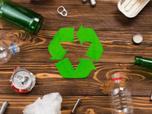 dei rifiuti su un tavolo al centro le frecce verdi simbolo del reciclaggio